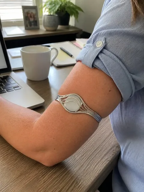 Silver bracelet worn at a home office desk