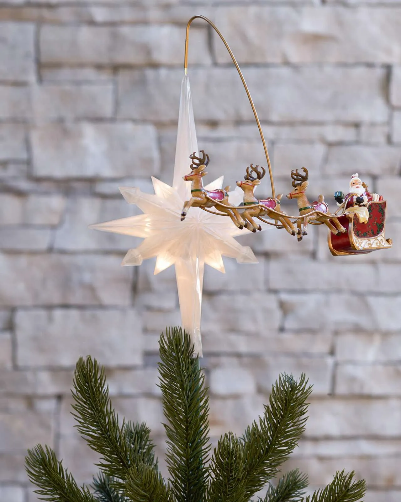 Santa sleigh and three reindeer circling a glowing tree topper star