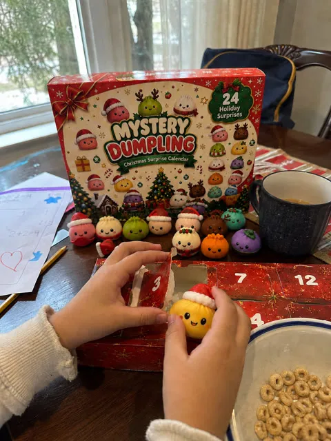Child opening a holiday dumpling surprise at the breakfast table