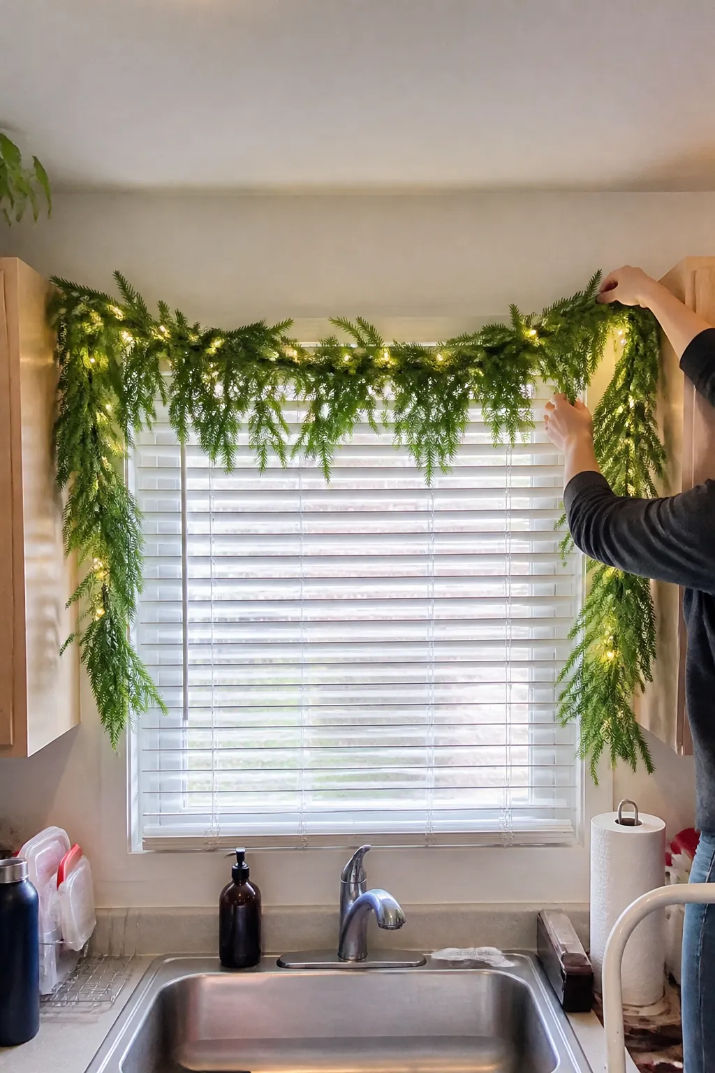 Lit pine garland arranged around a kitchen window