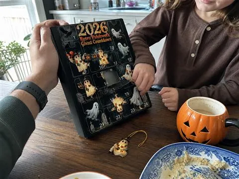 Family opening one patchwork ghost ornament at the kitchen table