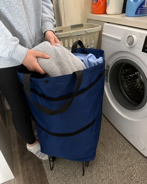 Navy rolling tote beside a washing machine