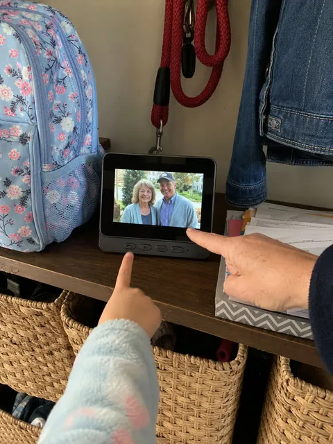Family hands pointing to familiar visitors on the indoor monitor
