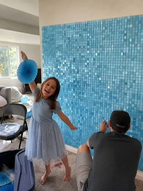 Family finishing a light-blue shimmer party backdrop