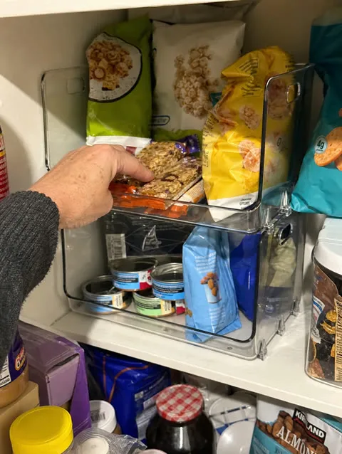 Clear open-front bins organizing a pantry shelf