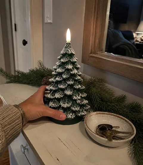 Snow-frosted tree candle on an entry console