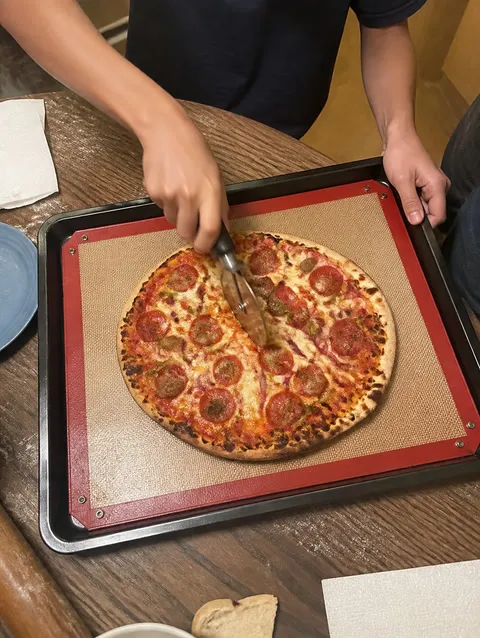 Red snap-corner baking mat used for family pizza night