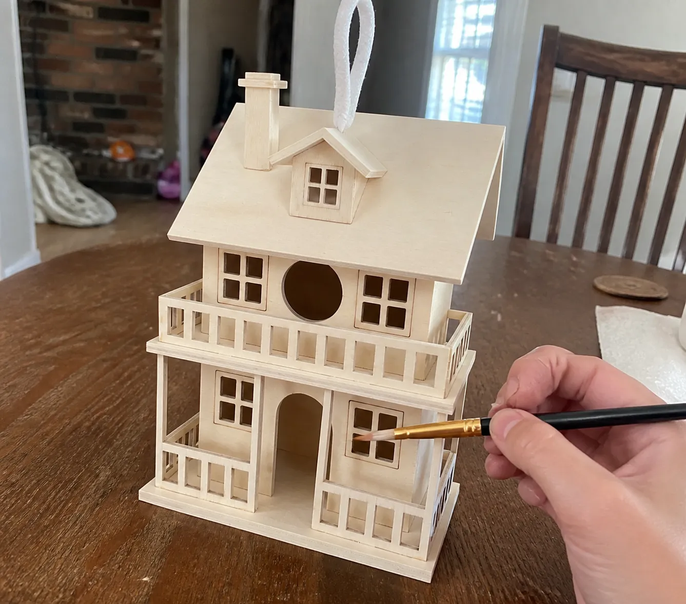 Unfinished birdhouse on a home craft table