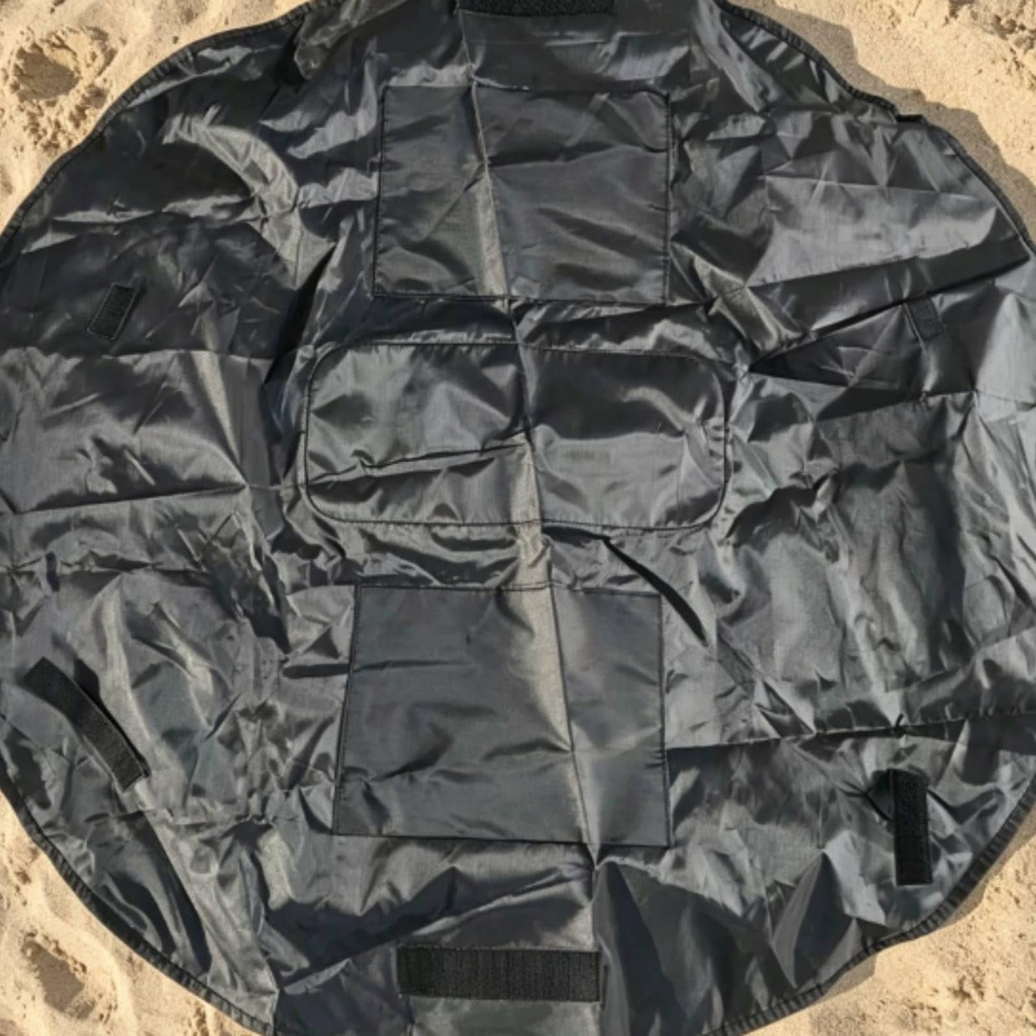Black round organizer mat with multiple sewn storage sections Black round organizer mat with multiple sewn storage sections