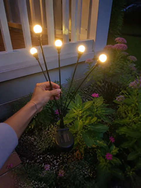 Solar light being placed in a flower bed