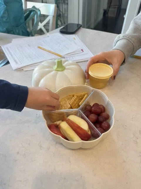 Cream divided pumpkin snack tray on a kitchen island after school