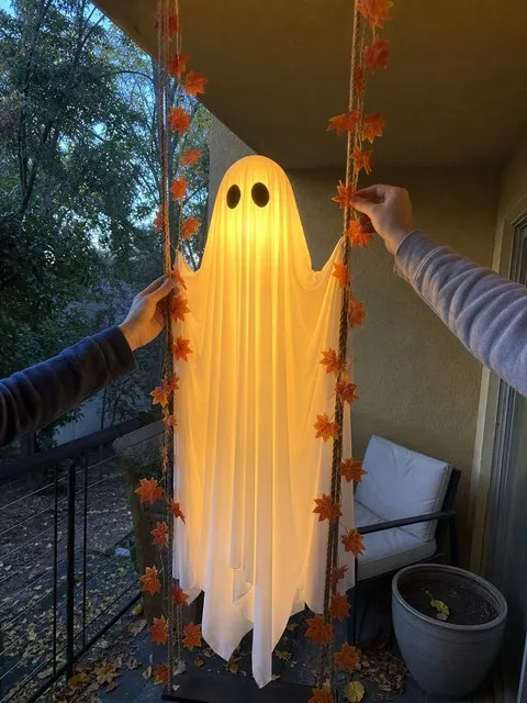 Adjusting maple leaves on a glowing balcony ghost swing