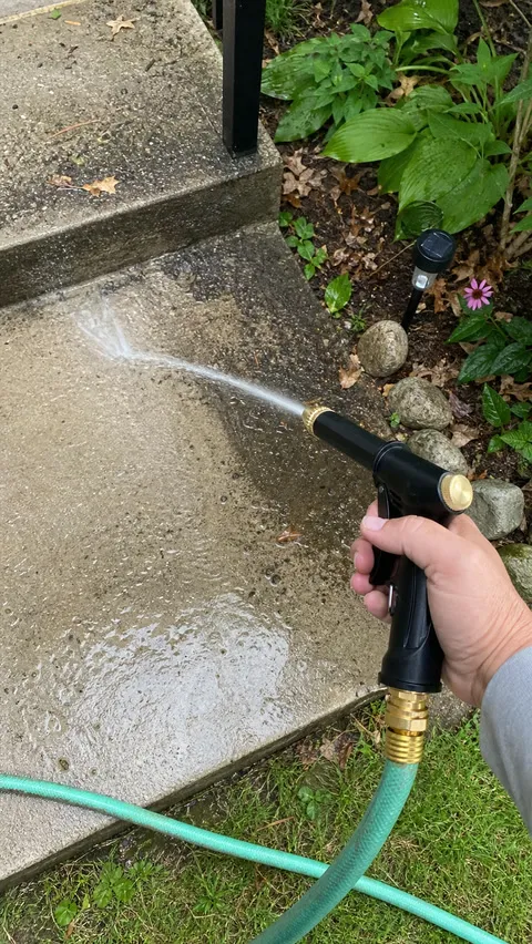 Concrete garden steps being rinsed with the portable hose sprayer