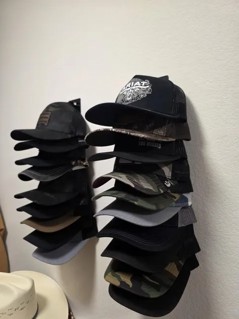 Two wall-mounted organizers holding a large cap collection