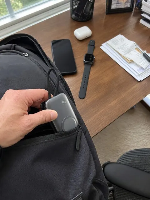 Pocket-size 3-in-1 charger beside a backpack and daily work essentials