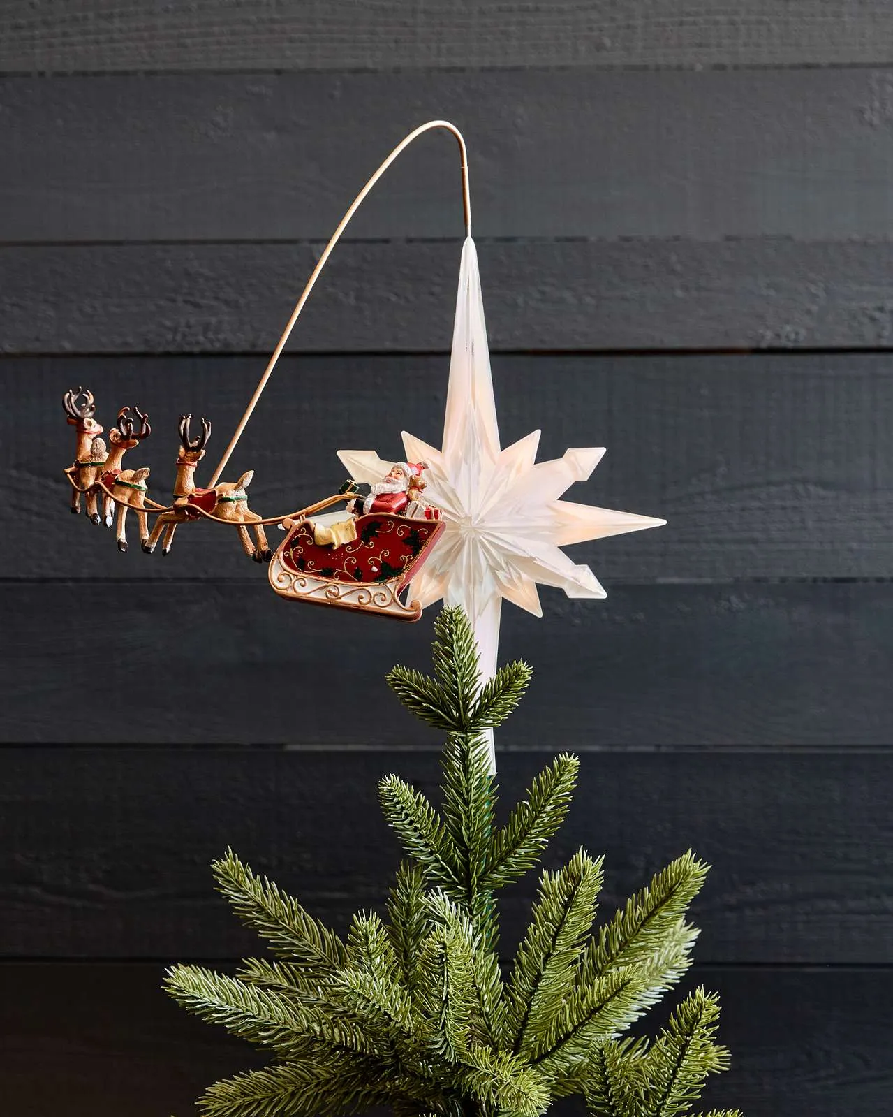 Glowing Santa sleigh topper displayed on a decorated tree