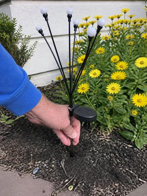 Solar light stake being installed in a front garden