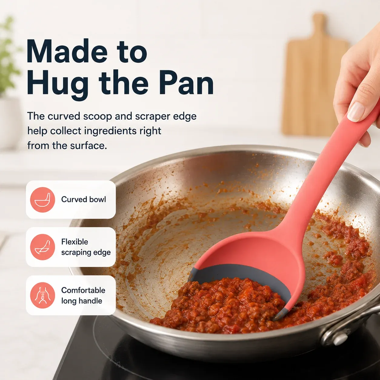 Silicone scoop scraper spoon following the curve of a pan to collect sauce
