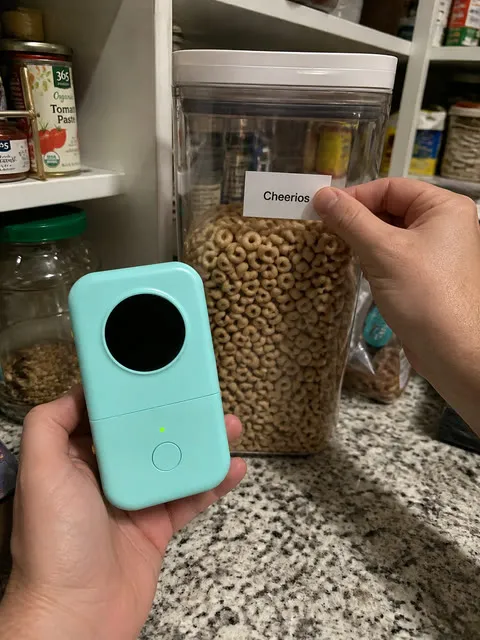 Mint label printer beside a labeled pantry container