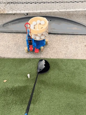 Golf ball dispenser feeding a ball toward the practice position