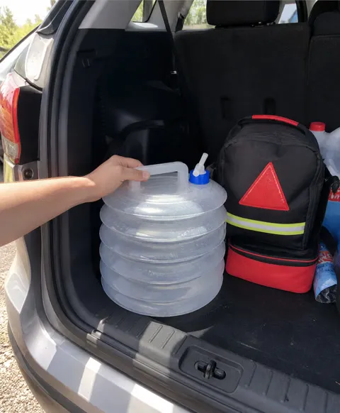 Collapsible water container stored with a roadside kit