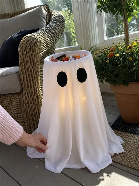 White ghost candy bowl being arranged on a bright screened porch