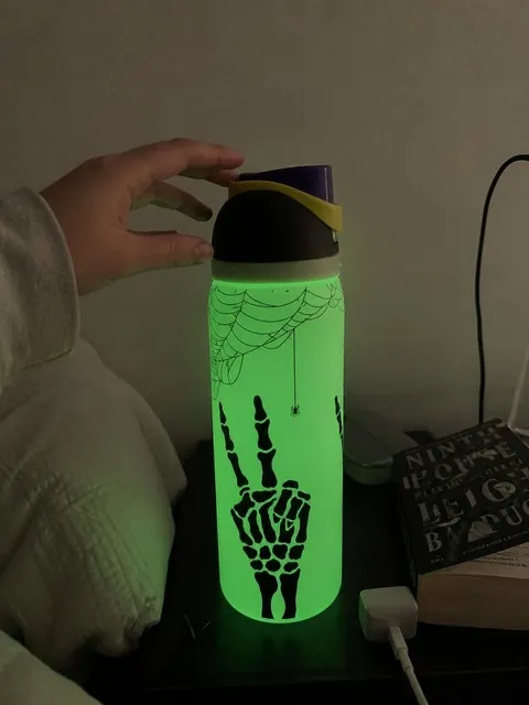 Glowing skeleton bottle on a lived-in bedroom nightstand
