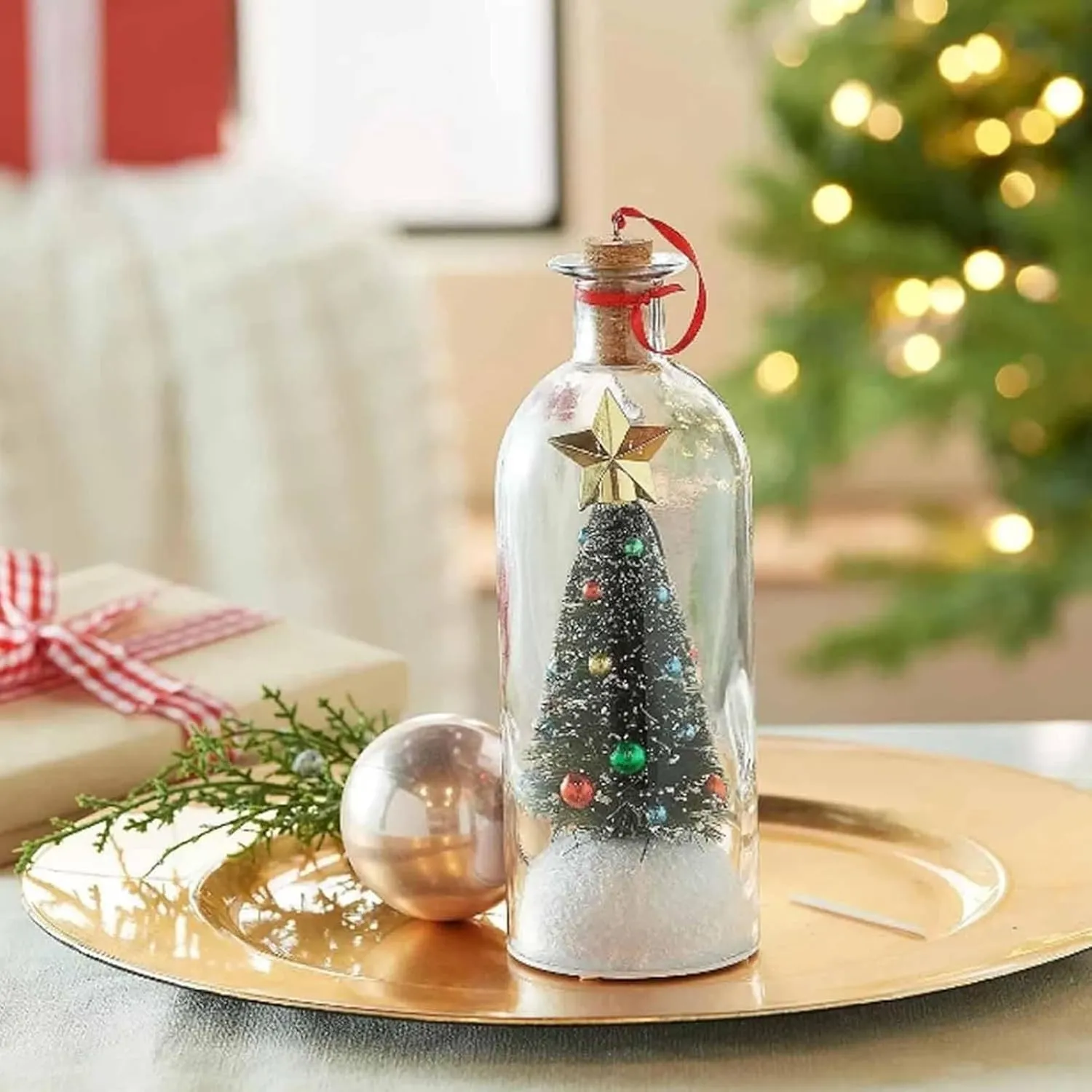 Recordable Christmas tree bottle displayed beside a holiday gift