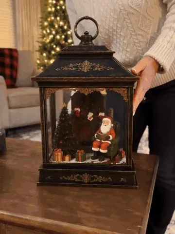 Christmas lantern lighting up with swirling snow in a cozy home