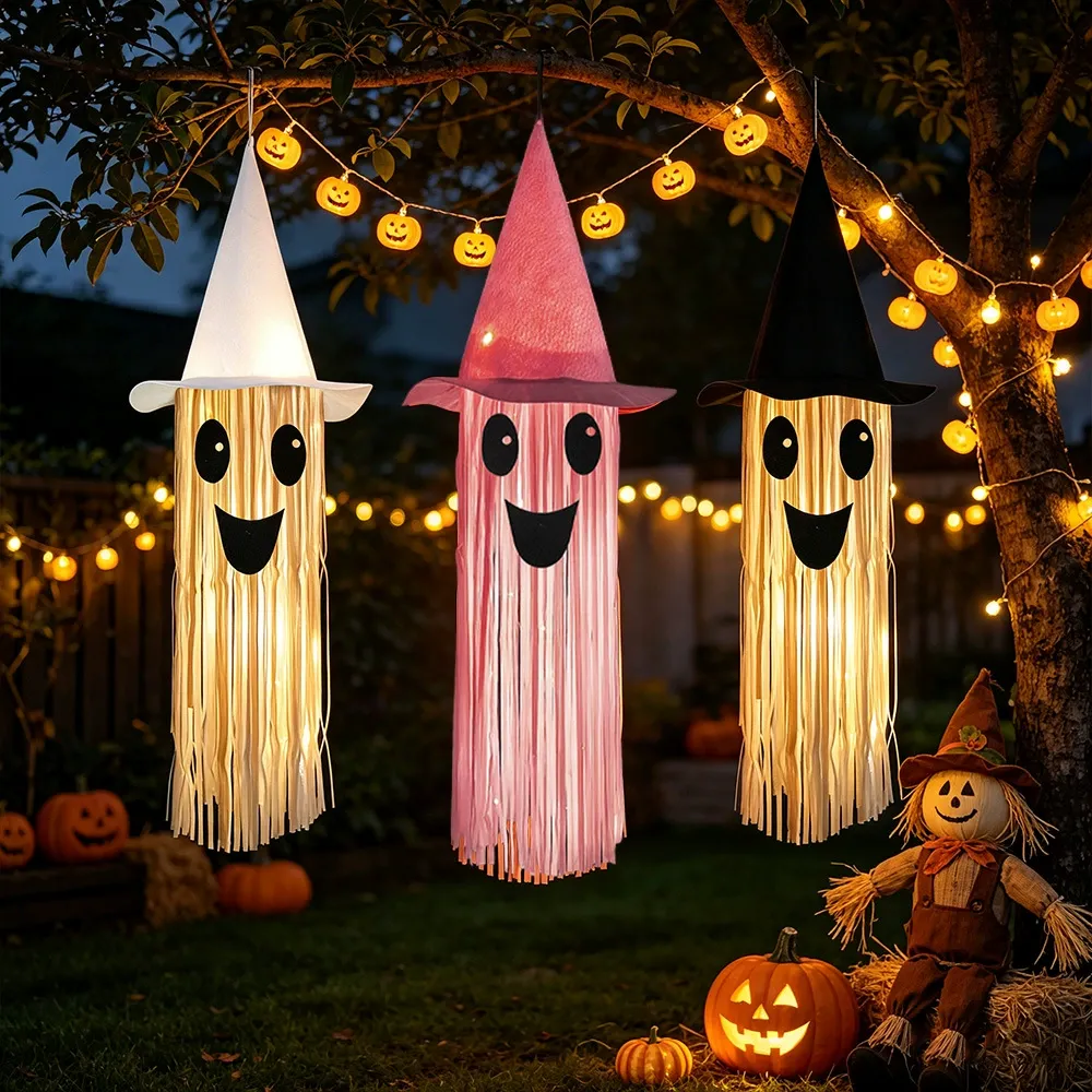White, pink, and black light-up tassel ghosts hanging outdoors