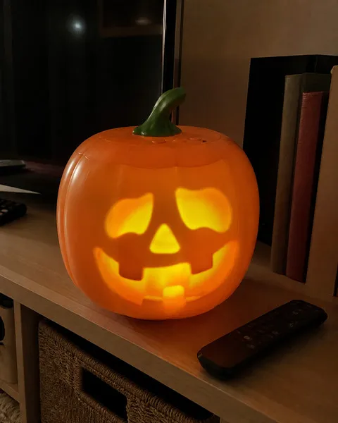 Animated pumpkin glowing on a family media shelf