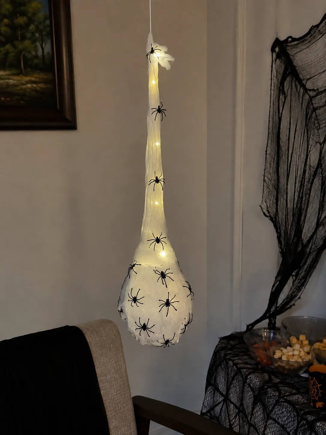 Spider egg sac glowing in an indoor Halloween party corner