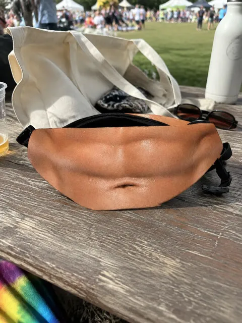 Muscle print novelty waist pack at an outdoor festival