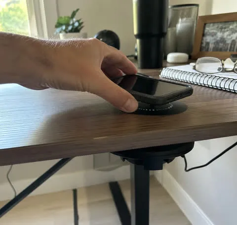 Phone placed on the charging marker at a home office desk