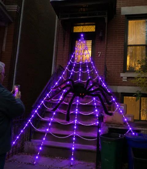 Large spider web light display on townhouse steps