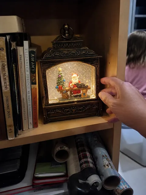 Santa workshop lantern on a lived-in craft room bookshelf