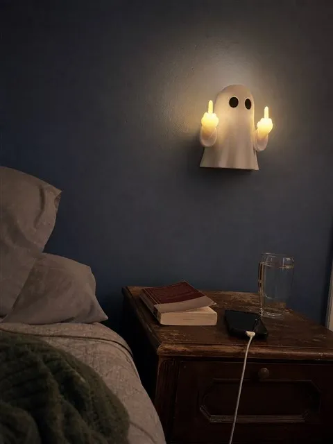 Ghost wall night light glowing above a lived-in bedroom nightstand