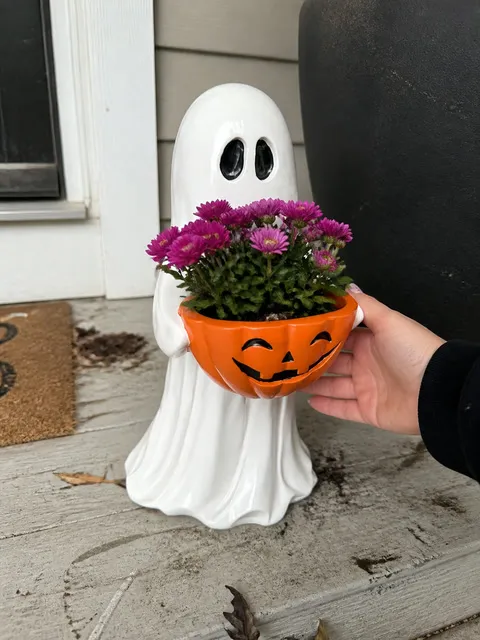 Ghost pumpkin bowl with purple flowers on a porch