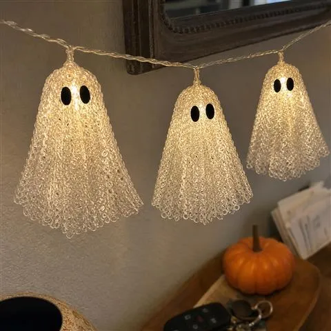 Close phone photo of the glowing lace texture on three ghost lights