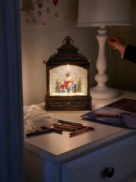 Snowman lantern glowing on a child's bedroom dresser