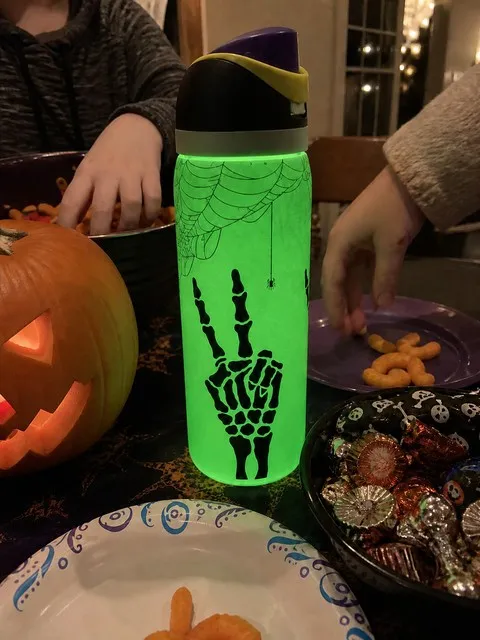 Glowing skeleton bottle at a casual family Halloween table