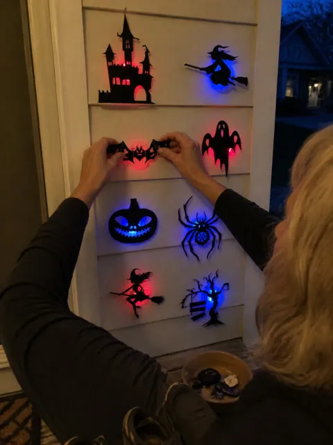 Halloween wall decorations being installed by an entryway