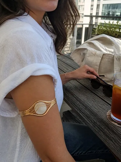 Gold bracelet worn on a sunny apartment patio