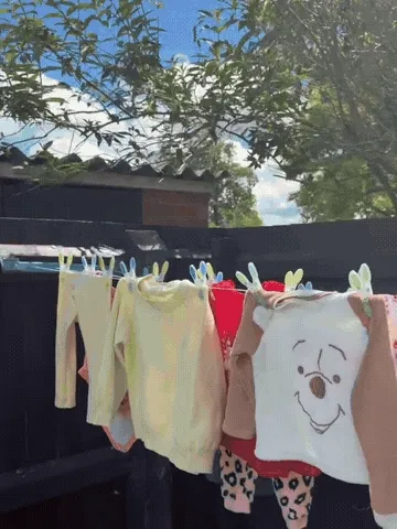 Retractable clothesline being pulled out and used to hang laundry
