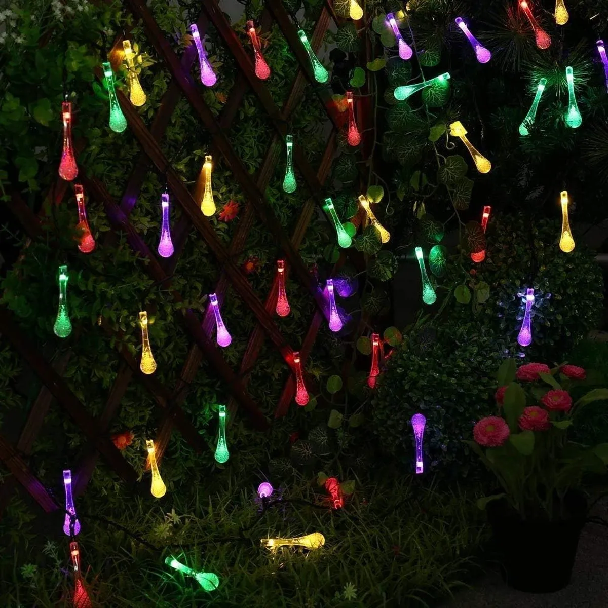 Multicolor waterdrop string lights decorating an outdoor tree