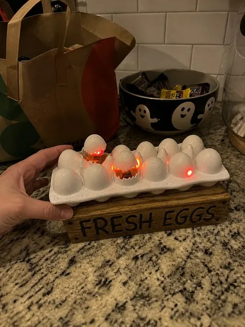 Zombie chick egg decoration beside a Halloween candy bowl