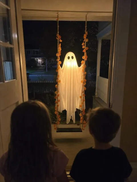 Children watching the glowing ghost from inside the front door