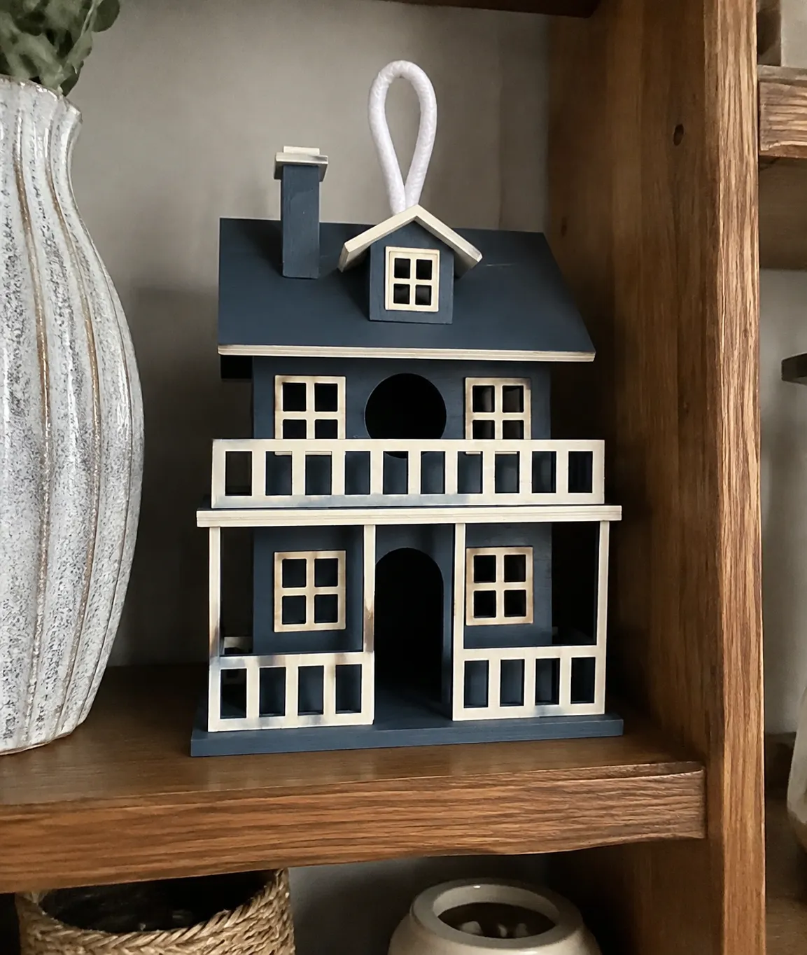Painted birdhouse displayed on a shelf