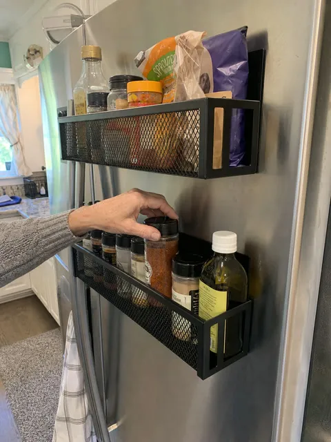 Spices organized in two black racks on a refrigerator