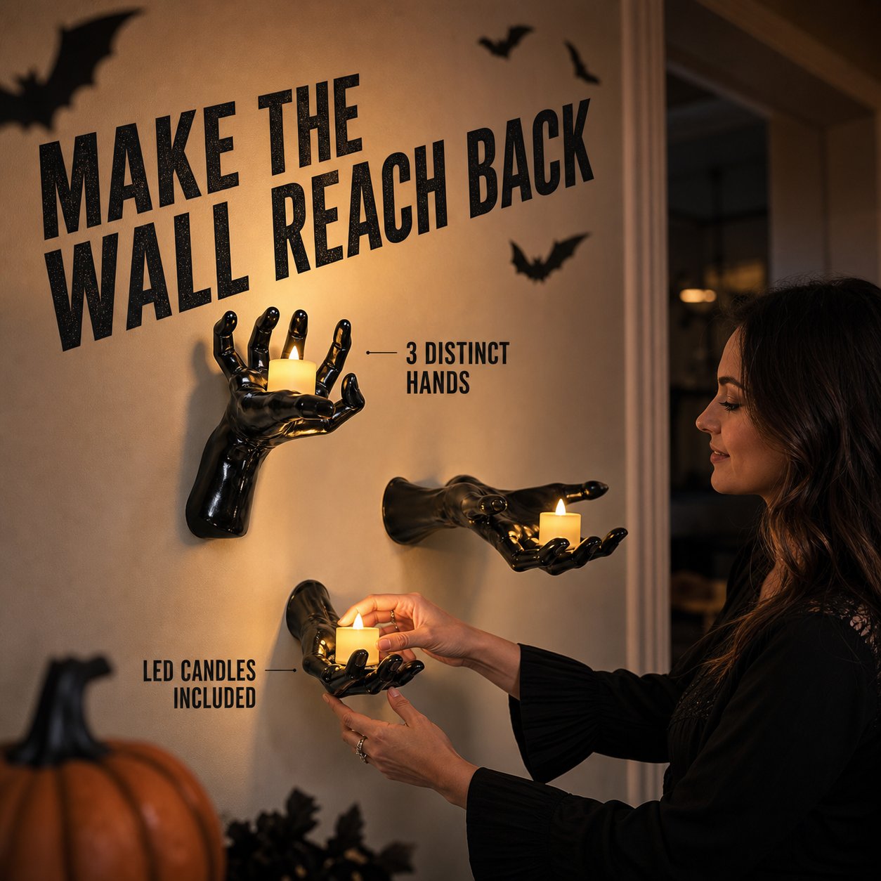 A homeowner arranging three creepy black hand candle holders on a wall